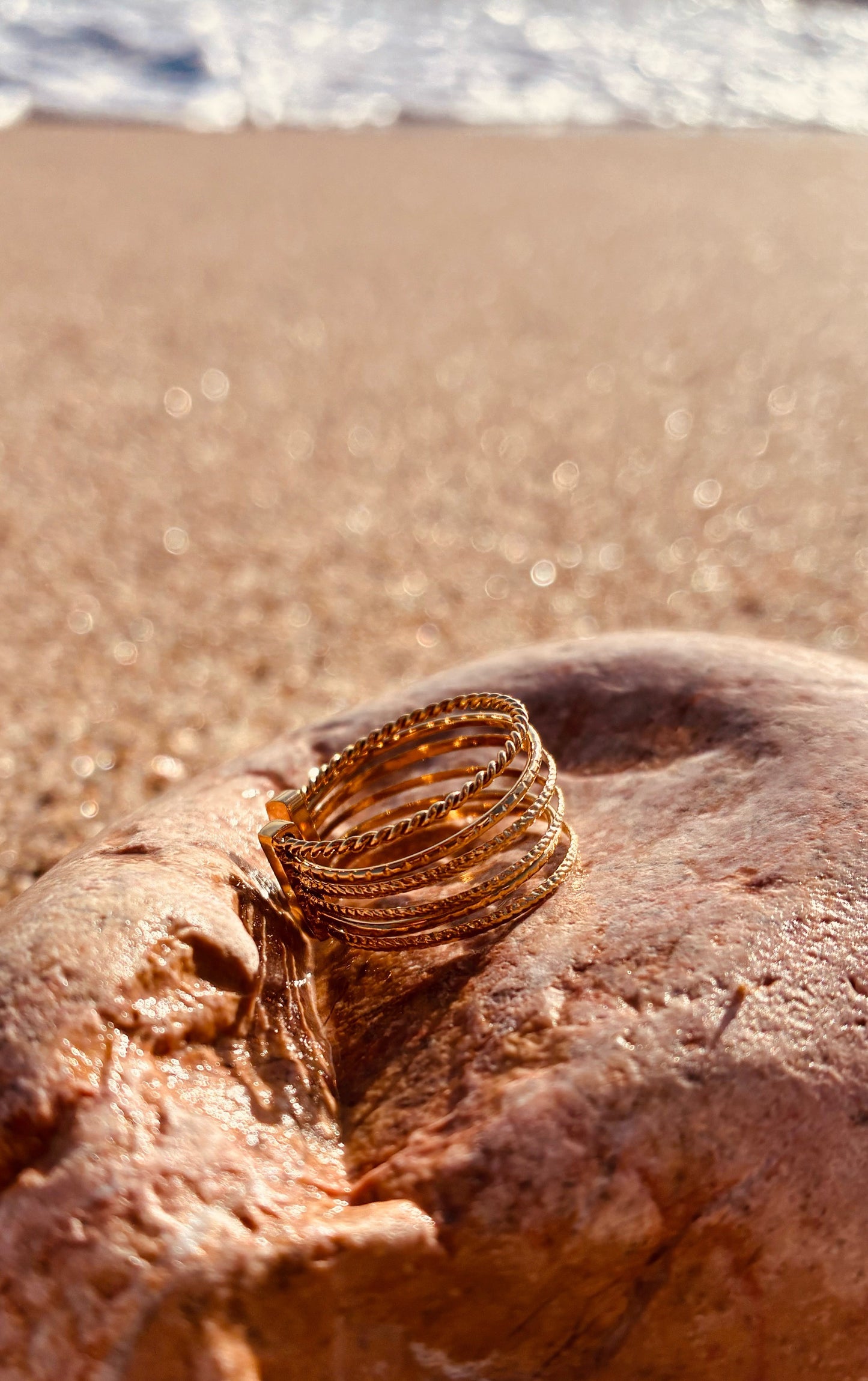 Bague acier inoxydable femme Lorena dorée ajustable multi anneaux style bohème chic sur galet plage