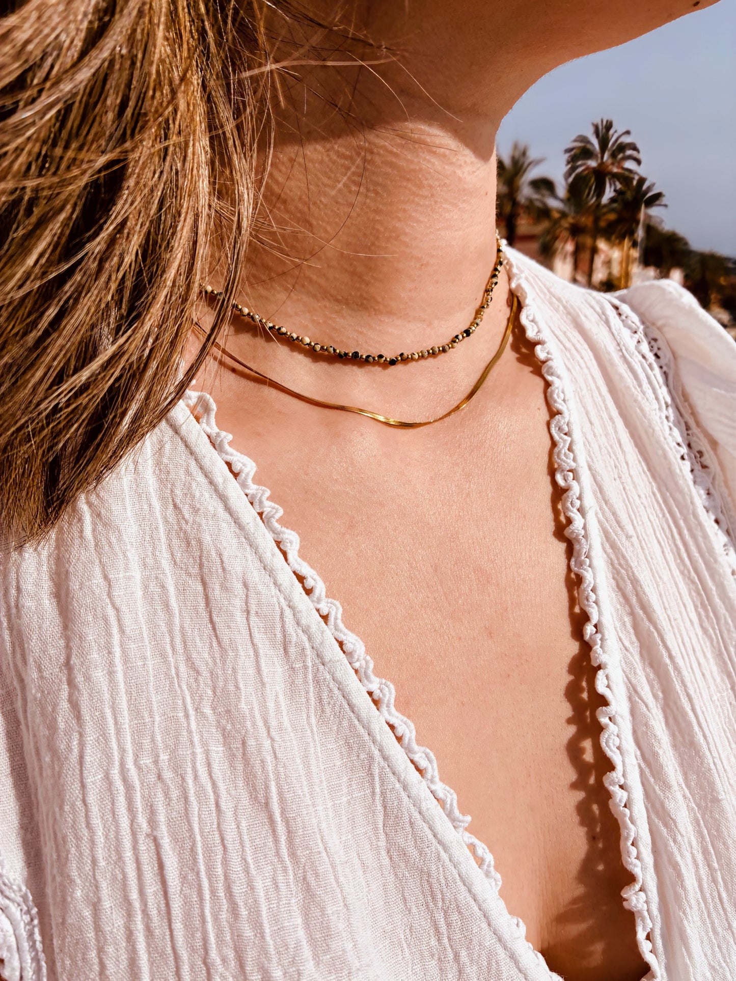 Collier Bella double rang en acier inoxydable doré et jaspe dalmatien porté sur peau, bijou femme minimaliste