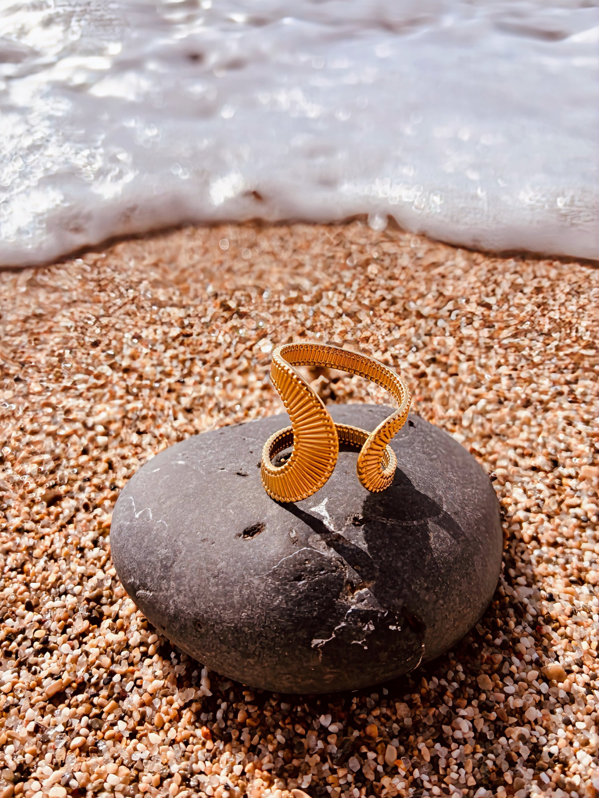 Bague acier inoxydable femme Aliyaah dorée ajustable design moderne sur galet plage