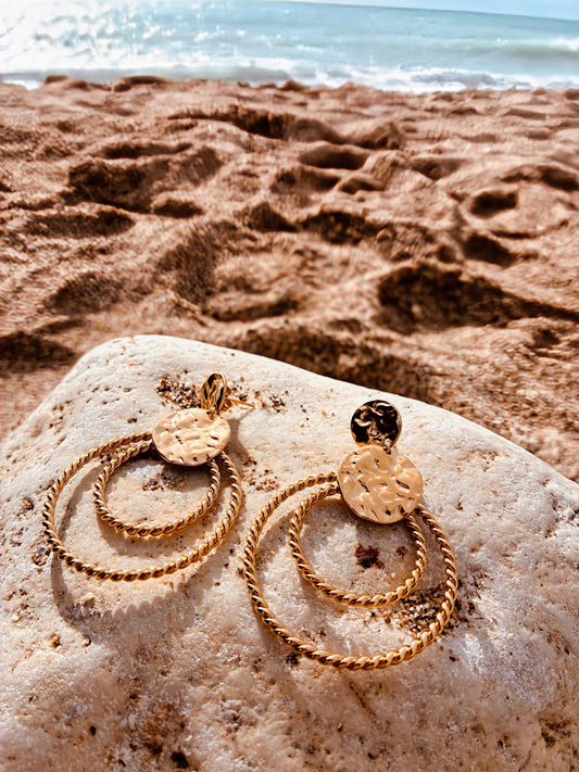 Boucles d’oreilles dorées femme Lina double anneau torsadé acier inoxydable sur galet plage